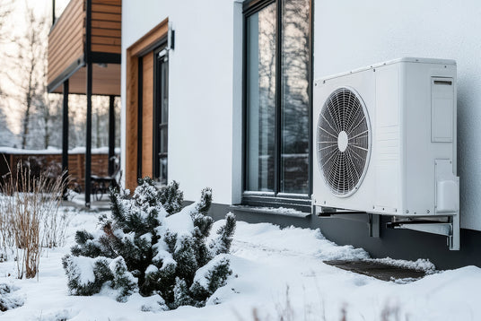 An outdoor heat pump unit in front of a modern house.